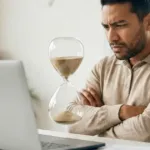Homme devant son ordinateur observant un sablier, illustrant un site WordPress lent